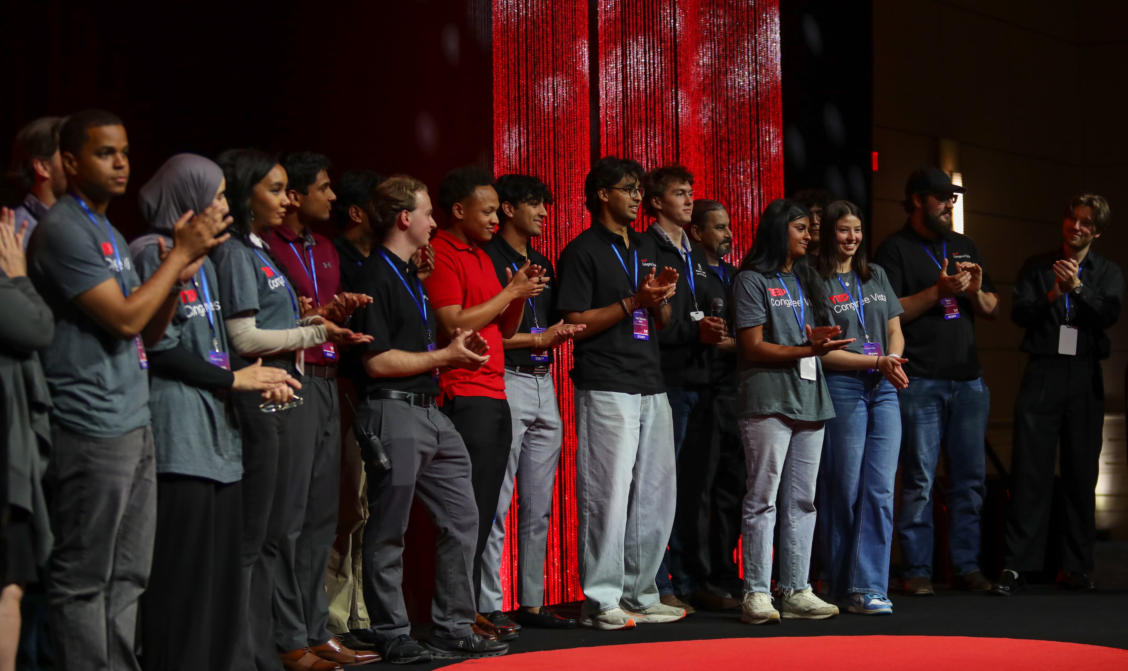 The full Inspire Columbia team applauding together on stage at TEDxCongaree Vista